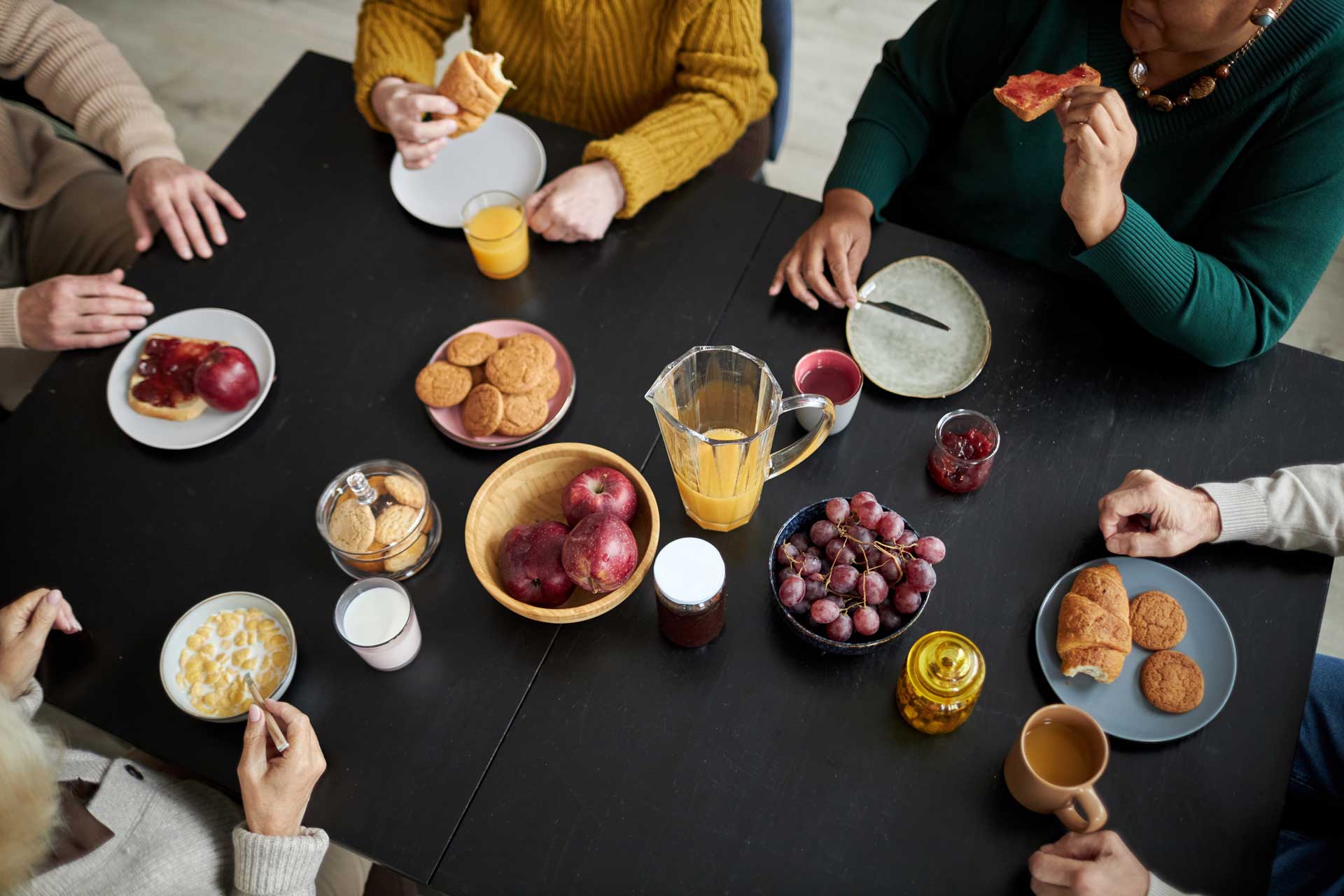 Community_Culinary_Delight_578990373_web an overhead shot of a group of people having breakfast